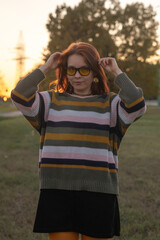 Portrait of a young beautiful red-haired girl in an autumn city park.
