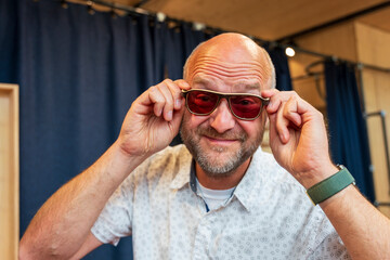 Happy man with bald head and sun glasses at shop 