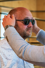Happy man with bald head and sun glasses at shop 