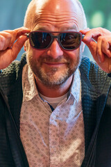 Happy man with bald head and sun glasses at shop 