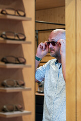 Happy man with bald head and sun glasses at shop 