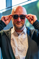 Happy man with bald head and sun glasses at shop 