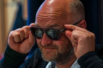Happy man with bald head and sun glasses at shop 