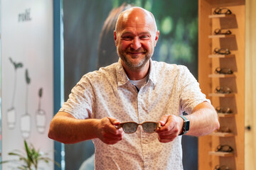 Happy man with bald head and sun glasses at shop 