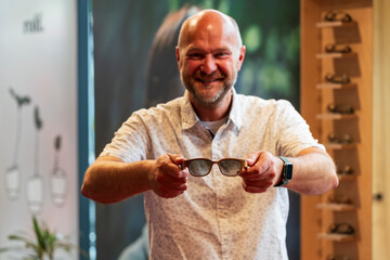 Happy man with bald head and sun glasses at shop 