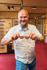 Happy man with bald head and sun glasses at shop 