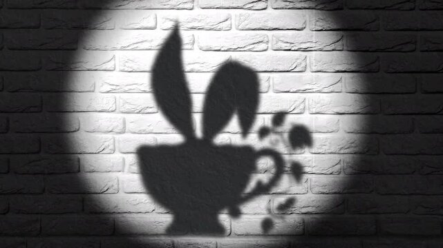 Black and white film footage of a shadow of a whimsical teacup with bunny ears on a brick wall illuminated by a spotlight