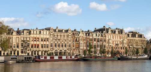 Panorama with historic apartments along the Amstel River in the center of Amsterdam.