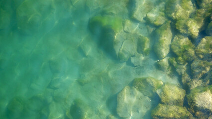 Obraz premium Water surface wits stones on the bottom top view. Background abstracted wallpaper texture