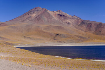 View of the dark blue Miniques lagoon and mountains, Miscanti lagoon in Chile Atacama desert near...