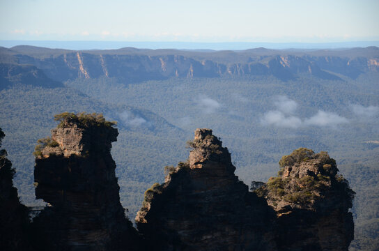 Three Sisters rock formation with misty blue mountains backdrop, Australia - Powered by Adobe