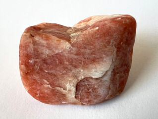 Red Triplite stone, object on white background. Rare phosphate monoclinic mineral, top quality used in jewelry as a gemstone.