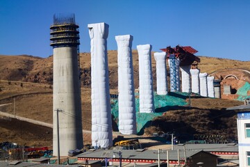 Massive railway construction site in the Amdo region of Tibet, showcasing intrusive infrastructure disrupting the traditional plateau landscape.