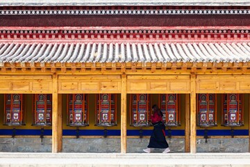 An female pilgrim pushing the longest Tibetan prayer wheels in the world at Labrang Monastery, one of the largest monastery in Amdo region (now Gansu) during Butter Lamp Festival. 