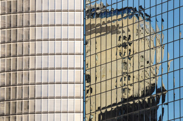 Abstract urban reflection with distorted architecture on glass high-rise facade