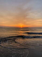 Golden Sunset Over Calm Water with Rays Through Cloud