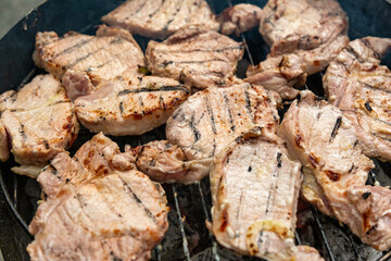 Grilled meat steak on stainless grill depot with flames on dark background. Food and cuisine concept.