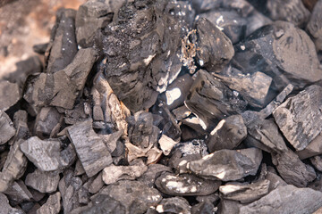 Black burning wood charcoal on a fire background.