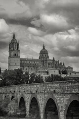 View of the Roman Bridge and New Cathedral of Salamanca, Spain, with dramatic clouds over the...