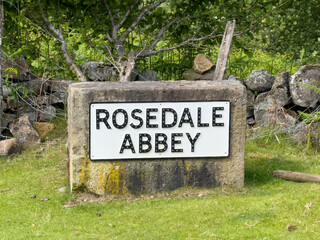Stone sign indicating Rosedale Abbey in North York Moors National Park, England, showing a beautiful countryside landscape