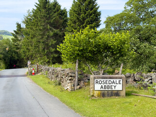 Stone sign indicating Rosedale Abbey in North York Moors National Park, inviting exploration of this historical landmark amidst picturesque landscape