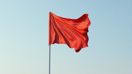 Red flag waving in light blue sky