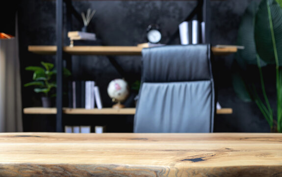 Modern business office with leather chair and wooden desk in front of elegant bookshelf with decor and books. Workspace interior for executive or entrepreneur