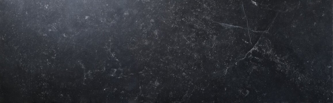 Flat lay of dark soapstone slab with subtle white veins and fine surface texture