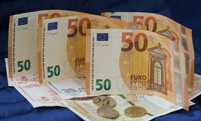 Rows of fifty Euro banknotes with Bulgarian leva and coins on blue background. Bulgaria in Eurozone. Bulgarian National Currency, National Bank. Adoption of common European currency