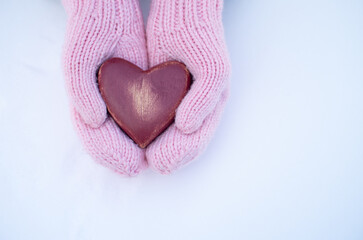 Female hands in mittens with heart, close up