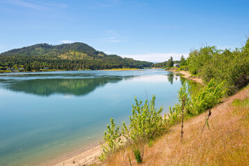 Late Spring view from the riverfront Le Clerc road of the Pend Oreille River as it runs through the small town of Newport, Washington, in the Northeast region of the state.