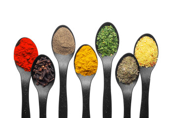 A row of black spoons filled with various colorful spices and seasonings