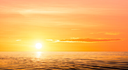 Sunrise sky over sea in the morning with sun and yellow sunlight on colorful horizon sky background in golden hour time, Beautiful gold sunset summer sky with light reflection on water surface