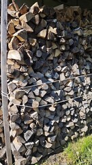 Stack of firewood neatly arranged and tied with rope in the backyard. Concept of rural preparedness, natural fuel and seasonal tradition