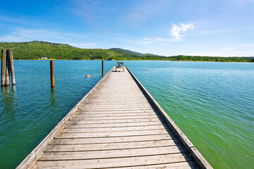 A wooden dock juts out into the Pend Oreille River near the Riley Creek Recreation Area at the rural small town of Laclede, Idaho.