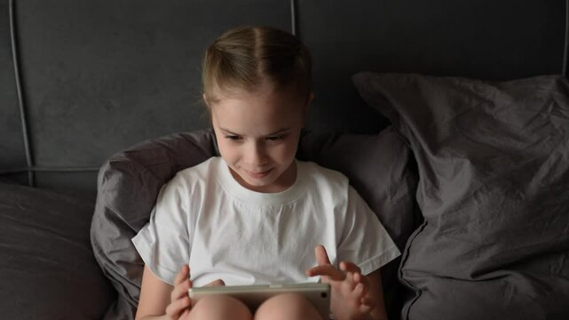 child playing tablet, little girl playing tablet, Relaxed child scrolling, under soft covers, reading online, watching video, immersive moment, soft hands, side pose, child and screen, night habit