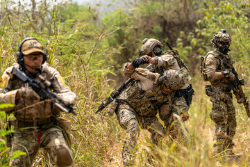 Fototapeta premium Soldier Carrying Injured Comrade During Tactical Combat Mission – Military Rescue Operation in Jungle, Armed Forces in Full Gear Providing Assistance Under Fire, Real Battlefield Scene