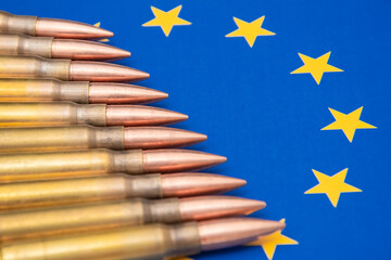 The ammunition lies against the background of the EU flag, emphasising the theme of military...