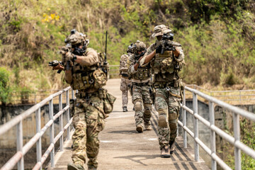 Special Forces Unit Conducting Tactical Patrol on Bridge – Armed Soldiers with Rifles and Full...