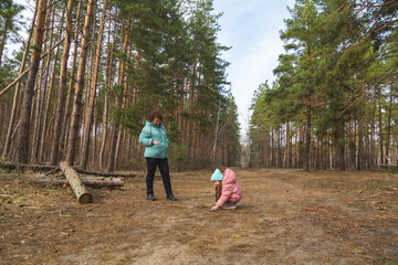 Grandmother with granddaughter walking in nature in the forest