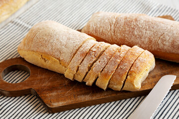 Homemade Ciabatta Bread on a wooden board, side view.