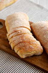 Homemade Ciabatta Bread on a wooden board, side view.
