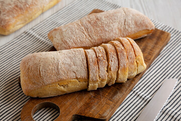Homemade Ciabatta Bread on a wooden board, side view.