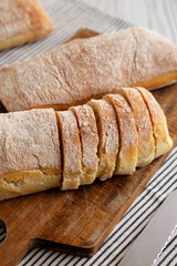 Homemade Ciabatta Bread on a wooden board, side view.