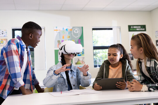 In school, diverse students using virtual reality and tablets, actively engaging in learning