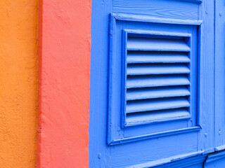 Bunte Hausfassade mit Türjalousie