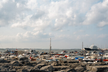 Bustling Kartal Marina in Istanbul Turkey with Colorful Fishing Boats, Luxury Yachts and Sailboats Moored in Sunny Mediterranean Harbor with Rocky Coastline