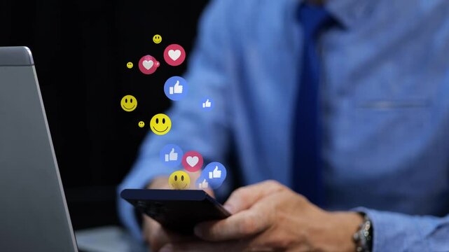 Businessman on social media during office break. 3D emoji icons like heart and smile float over the phone. Graphic animation