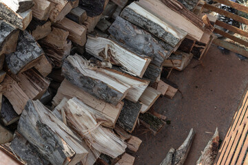 Stacked firewood logs drying in preparation for winter, offering sustainable energy and warmth for...