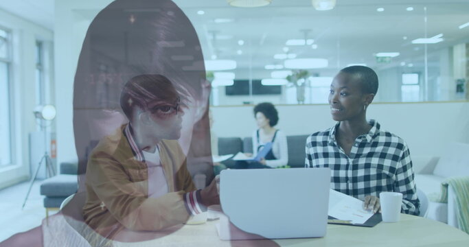 Showing portrait overlay of Native American woman in meeting at office, with laptop coffee mug - Powered by Adobe
